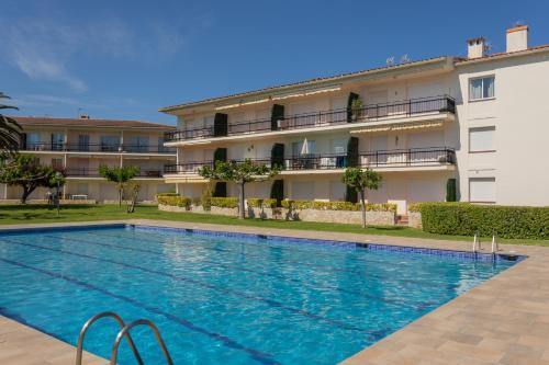 a swimming pool in front of a building at Apartament amb piscina i aparcament - Baixos amb jardinet in Calella de Palafrugell
