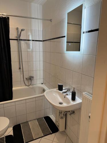 a bathroom with a sink and a tub and a toilet at Modernes Apartment in Essen Nähe Messe in Essen