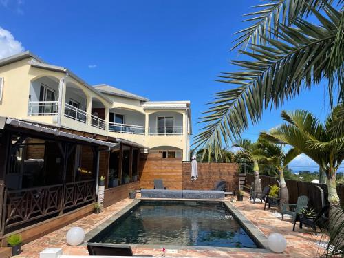 a house with a swimming pool in front of it at Harmonie de 3 logements- Villa des 4 Sens in Le Tampon