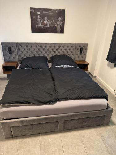a bed with black sheets and pillows on it at Modernes Apartment in Essen Nähe Messe in Essen