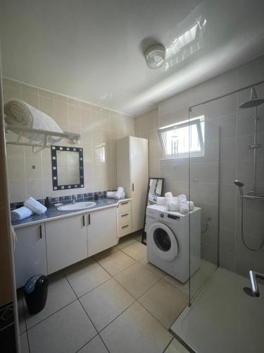 a kitchen with a washing machine and a sink at Harmonie de 3 logements- Villa des 4 Sens in Le Tampon