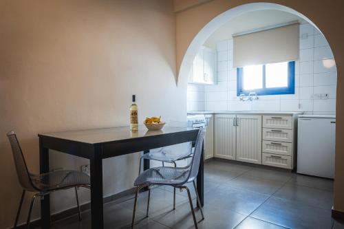 a kitchen with a black table and two chairs at Kefalos Damon Hotel Apartments in Paphos City