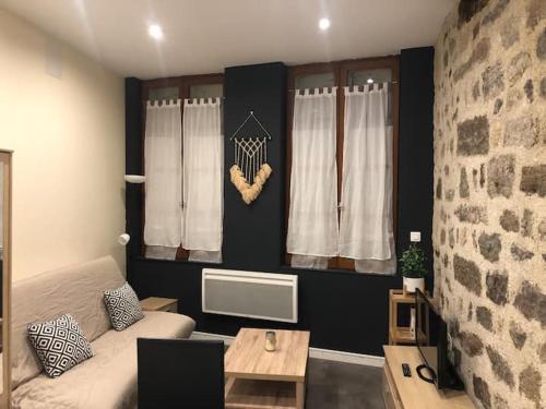 un salon avec un canapé et une table dans l'établissement Studio lumineux au 1er étage, au Puy-en-Velay