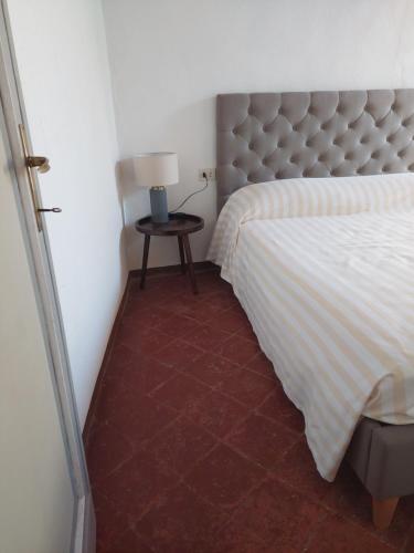 a bedroom with a bed and a table with a lamp at Le Stanze del Ritrovino in Castiglione dʼOrcia