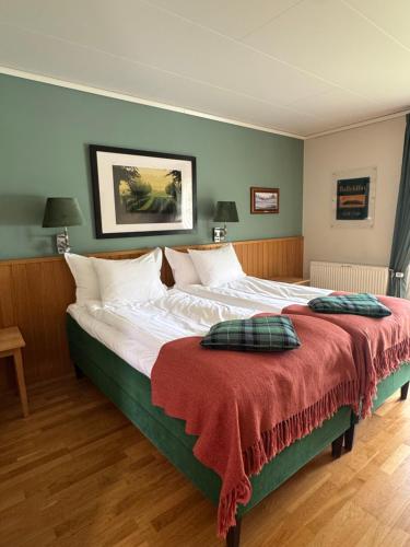 トローサにあるTrosa Åda Krog Hotell & Konferensの赤い毛布が掛けられた大きなベッドのある寝室