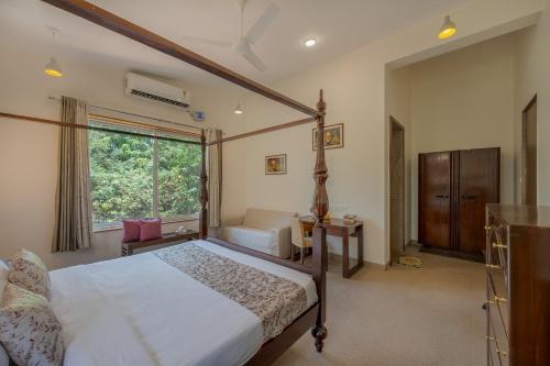 a bedroom with a bed and a couch and a window at SaffronStays Roselle, Malavli - pet-friendly pool villa with modern interiors in Lonavala