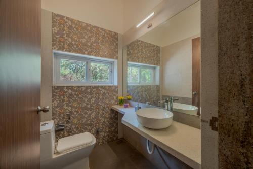 a bathroom with a sink and a toilet at SaffronStays Roselle, Malavli - pet-friendly pool villa with modern interiors in Lonavala