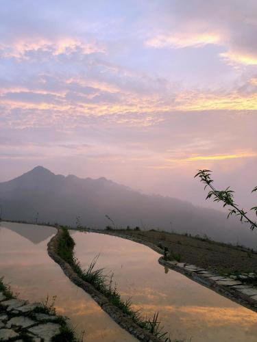 a view of a river with mountains in the background at Sunrise Ha Giang Camping An Introspective Stay in Kon Rung (1)
