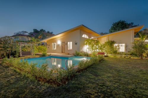 a house with a swimming pool in the yard at SaffronStays Roselle, Malavli - pet-friendly pool villa with modern interiors in Lonavala