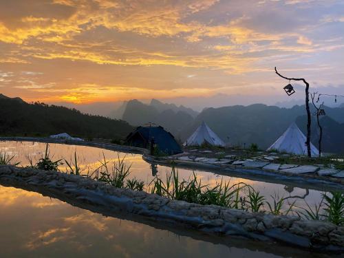 a group of tents in the mountains at sunset at Sunrise Ha Giang Camping An Introspective Stay in Kon Rung (1)