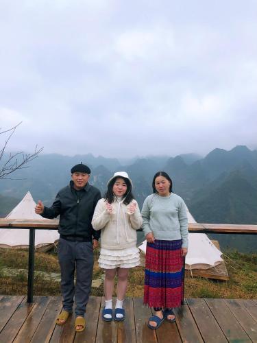 a group of three people standing on top of a mountain at Sunrise Ha Giang Camping An Introspective Stay in Kon Rung (1)