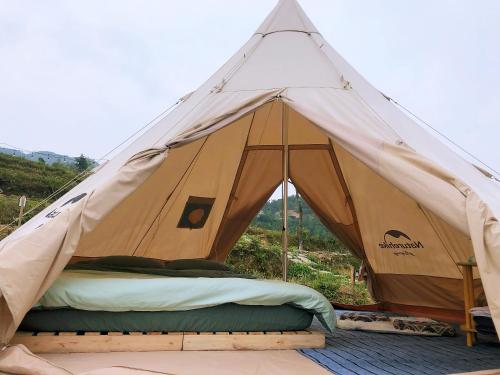 a tent with a bed in the middle at Sunrise Ha Giang Camping An Introspective Stay in Kon Rung (1)