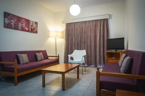 a living room with a couch and a table at Kefalos Damon Hotel Apartments in Paphos City