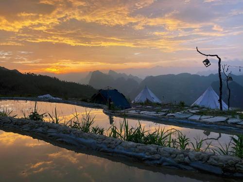 a group of tents in the mountains at sunset at Sunrise Ha Giang Camping An Introspective Stay in Kon Rung (1)