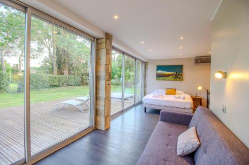 un salon avec un canapé et un lit dans l'établissement CABOTS Villa Moderne Tout Confort Grand Jardin & Piscine, à Biot