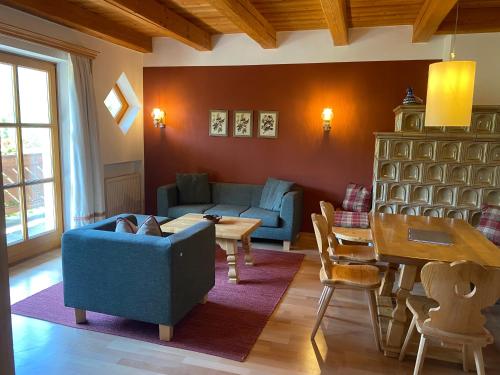 a living room with a blue couch and a table at Landhaus Sonneck in Weissensee