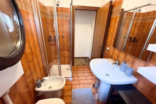 a bathroom with a sink and a toilet and a shower at BERNINA STATION CENTRE APARTMENT 3 - three minutes walk from bernina station in Tirano