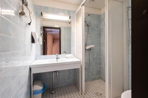 a bathroom with a sink and a shower at Hiisi Hotel Turku Seaport in Turku