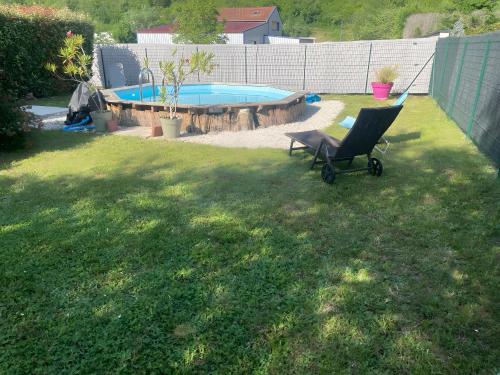a chair in a yard with a swimming pool at Maison de Violette in Serrières-de-Briord