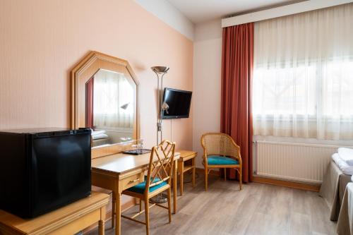 a hotel room with a desk and a television at Hiisi Hotel Turku Seaport in Turku