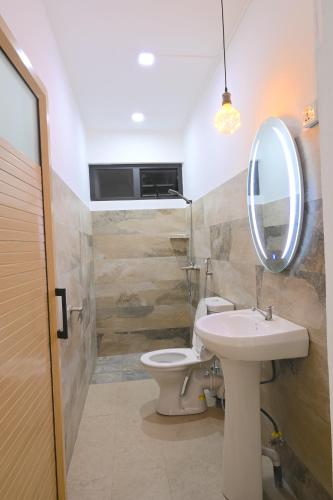 a bathroom with a sink and a toilet and a mirror at Lotus D`Or Villa in Trou aux Biches