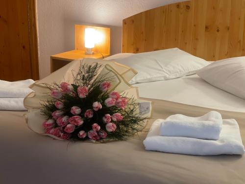 a bouquet of flowers on a bed with towels at Pensiunea Casa Dimitrios-Baile Herculane -Casă Boemă cu vedere la munte apă atmosferă intimă in Băile Herculane
