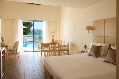a bedroom with a bed and a table and a dining room at Kiotari Bay in Kiotari