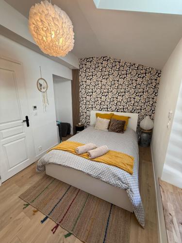 une chambre avec un grand lit et un lustre dans l'établissement Maison Sorbier, Appartement 1, à Nevers