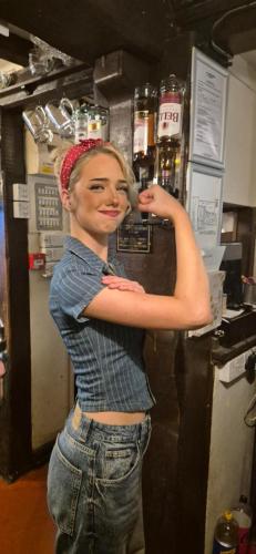 a woman standing in a kitchen with her arm on a counter at The Talbot Hotel in Ledbury