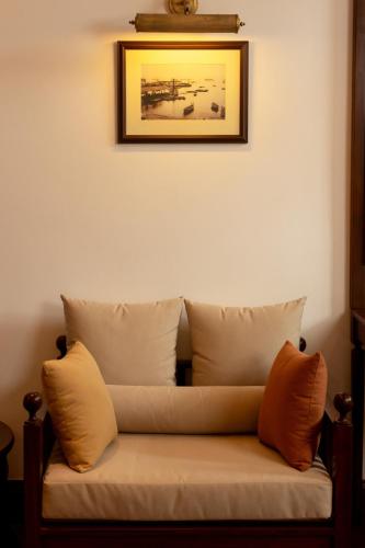 a couch in a room with a picture on the wall at Hotel Suisse Kandy - Since 1890 in Kandy