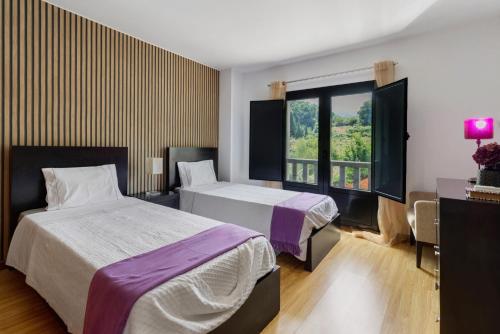 a hotel room with two beds and a window at Quinta Da Cevidade in Melgaço