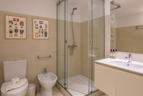 a bathroom with a shower and a toilet and a sink at Almada 151 - 2F in Porto