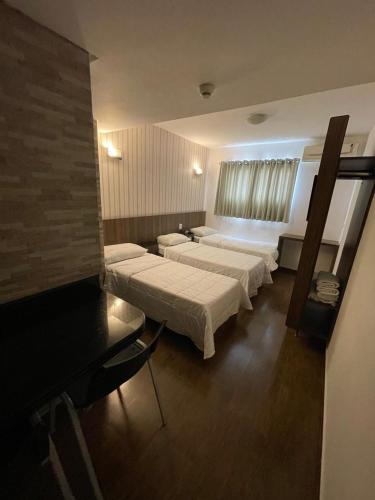 a hospital room with three beds and a television at Calandre Hotel in Sao Paulo