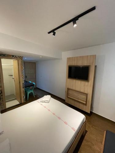 a bedroom with a bed and a flat screen tv at Calandre Hotel in Sao Paulo