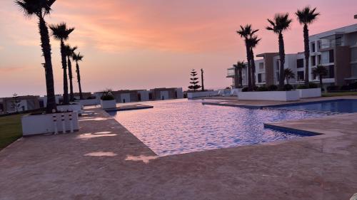 塞拉Un havre de paix的棕榈树泳池和日落背景