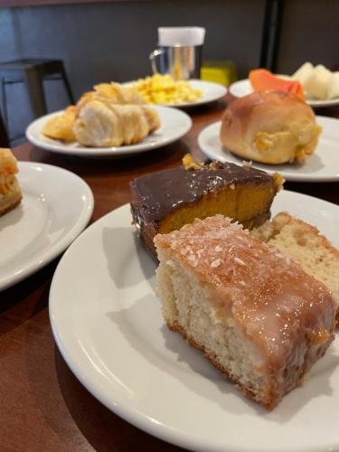 a table with plates of cake and pastries on them at Calandre Hotel in Sao Paulo