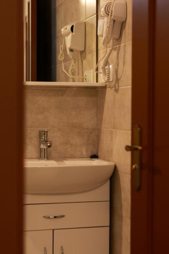 a bathroom with a sink and a mirror and a hair dryer at Ресторан-Готель Шеркерт in Berehove