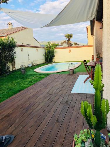 un cortile con una terrazza in legno e una piscina di Villa with pool a Maureillas