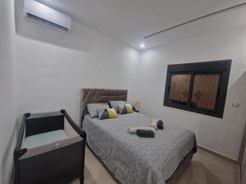 a bedroom with a bed in a white room at Appartement 3 pièces Saidia Centre ville in Saidia 