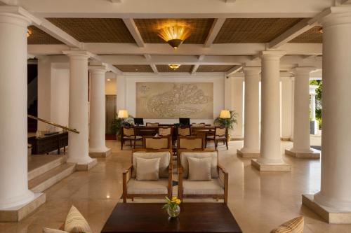a lobby with columns and a table and chairs at Hotel Suisse Kandy - Since 1890 in Kandy