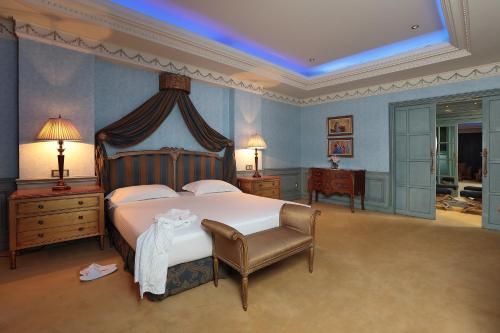 a large bedroom with a large bed and a chair at Le Royal Hotel - Beirut in Beirut