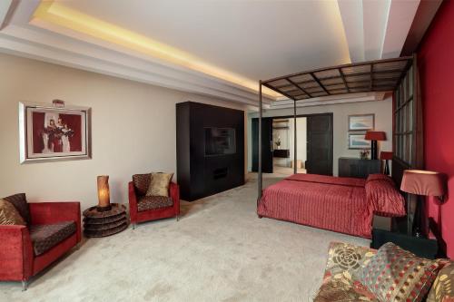 a bedroom with a red bed and red chairs at Le Royal Hotel - Beirut in Beirut