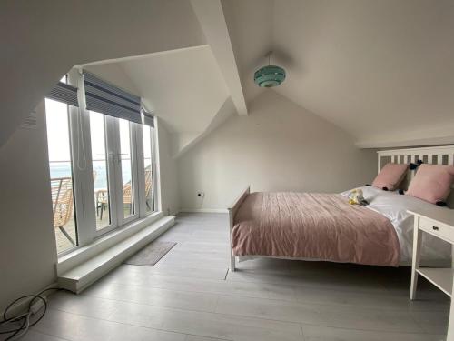 a bedroom with a bed and large windows at Cornwall Large Beach House Sea & Beach Views - 4 Bedrooms & 3 Bathrooms in Looe