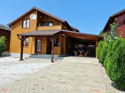 a wooden house with a clock on top of it at Cabana Giulia in Beclean