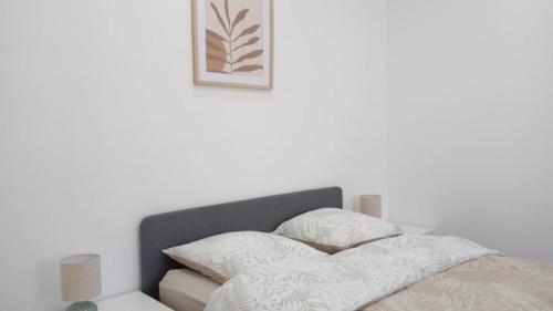 a bed with white sheets and pillows on it at La Parenthèse Verte - Garden - Air conditioning - Near center in Romilly-sur-Seine
