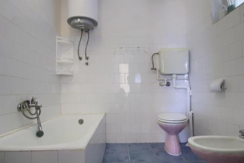 a white bathroom with a toilet and a sink at Olea House in Lukoran