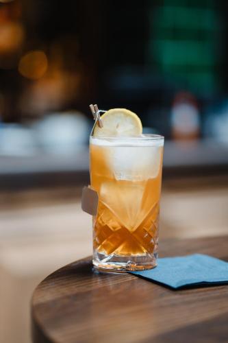 a glass of iced tea with a pickle on a table at The Royal Sutton in Sutton Coldfield