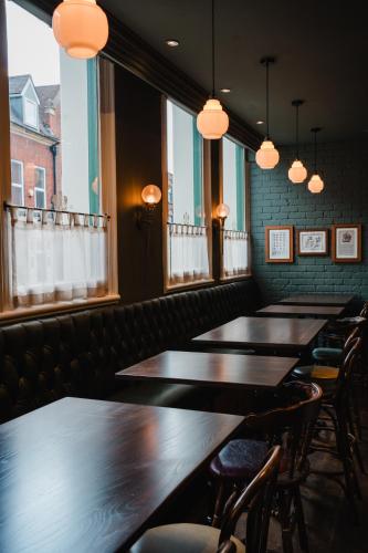 a row of tables in a restaurant with windows at The Royal Sutton in Sutton Coldfield