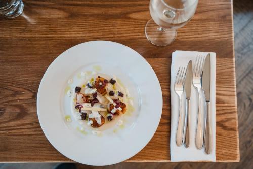 a white plate of food on a table with fork and knife at The Royal Sutton in Sutton Coldfield
