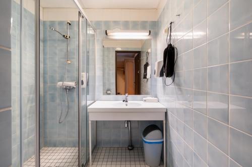 a bathroom with a sink and a shower at Hiisi Hotel Turku Seaport in Turku